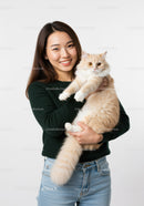 Smiling woman holding fluffy cream cat close
