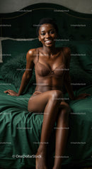 Smiling woman relaxed on dark green bed linen