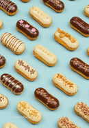 Assorted gourmet eclairs with elegant toppings on blue