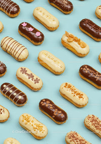 Assorted gourmet eclairs with elegant toppings on blue