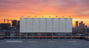 Urban Skyline at Sunset with Rooftop Billboard and Construction