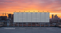 Urban Skyline at Sunset with Rooftop Billboard and Construction
