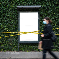Woman Wearing Mask Walking Past Closed Billboard With Caution Tape