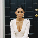 Elegant woman wearing white dress and pearl earrings