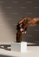 Elegant Brown Dropper Bottle with Hand Holding Aromatic Oil