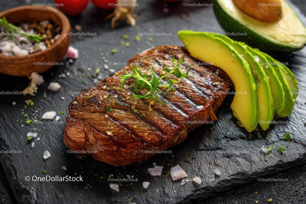 Juicy Grilled Steak with Sliced Avocado on Black Slate Plate