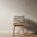 Stack of Neutral Folded Sweaters on Wooden Stool