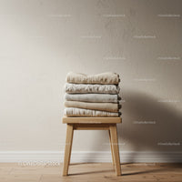 Stack of Neutral Folded Sweaters on Wooden Stool