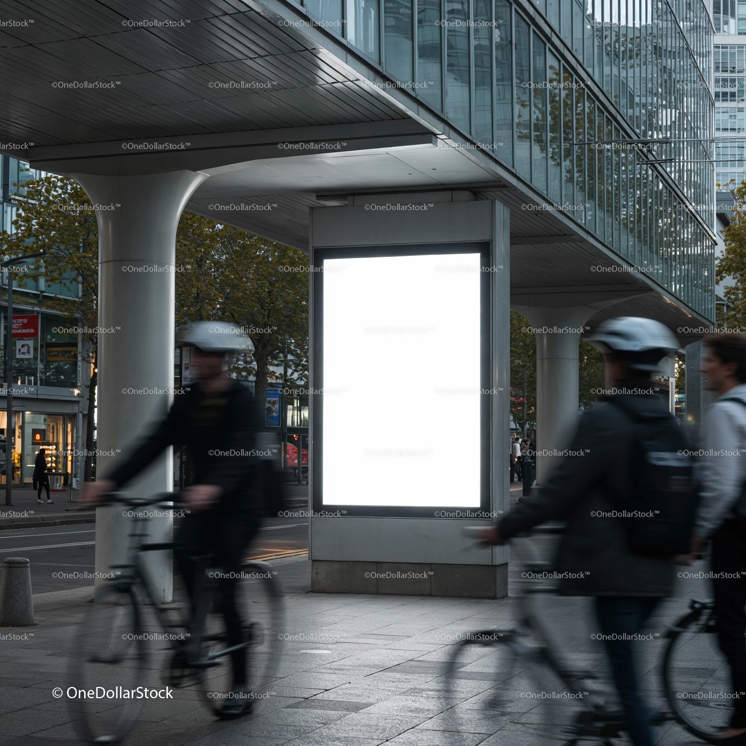 Urban cyclists passing by blank city advertisement board