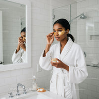 Young Woman Applying Skincare Mask in Modern Bathroom