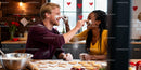 Couple playfully baking heart cookies in cozy kitchen