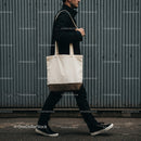 Man walking with canvas tote bag against metal wall
