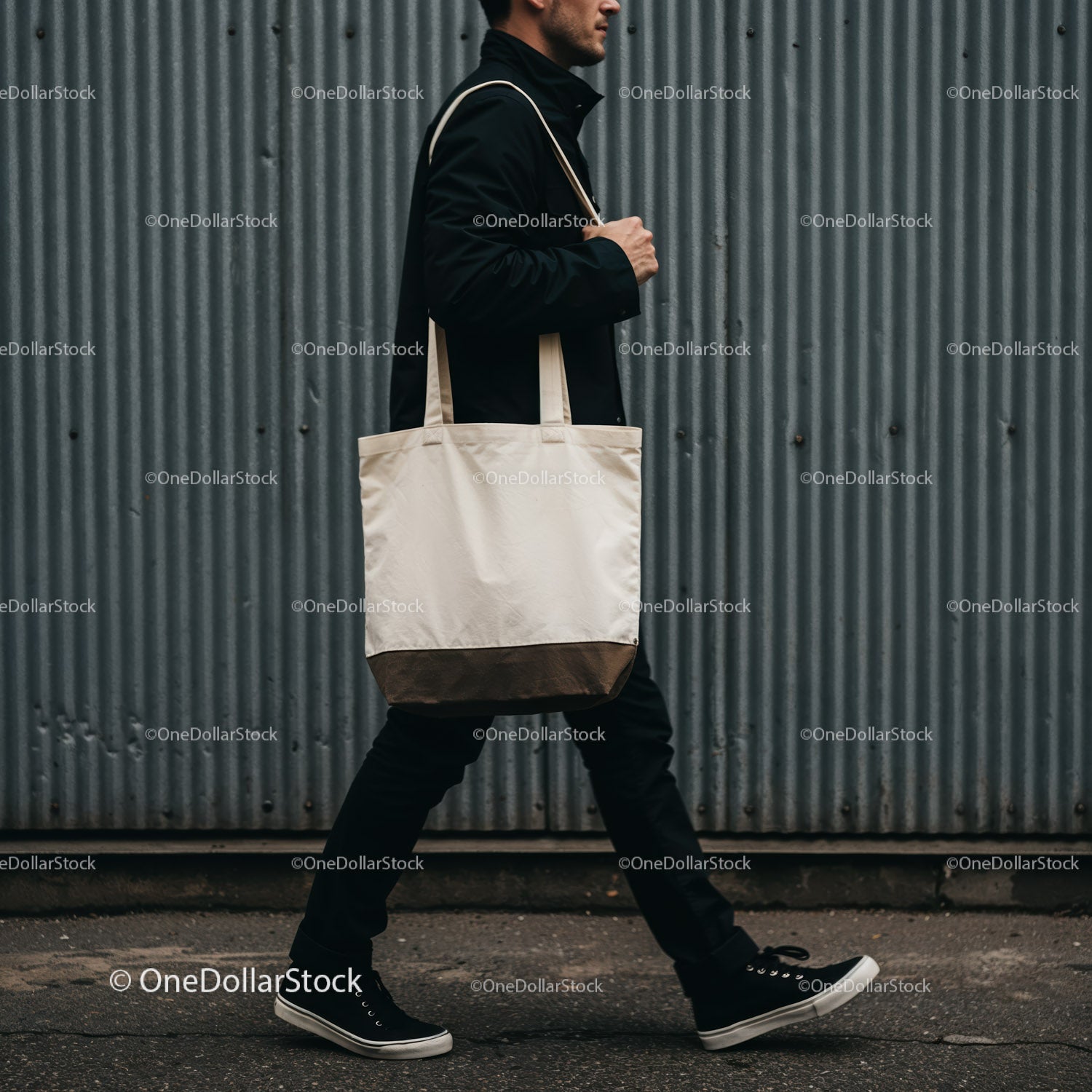 Man walking with canvas tote bag against metal wall