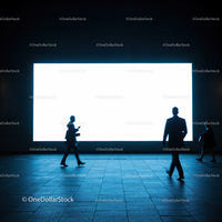 Silhouettes of business people walking by illuminated screen