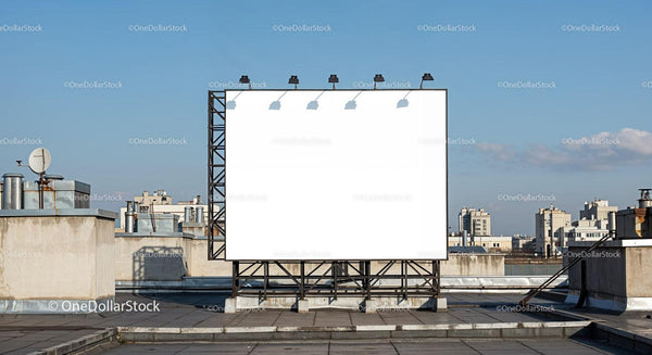 Large blank billboard on an urban rooftop under clear sky JPG Mockup Image