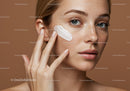 Woman Applying Face Cream for Skincare Routine with Blue Eyes