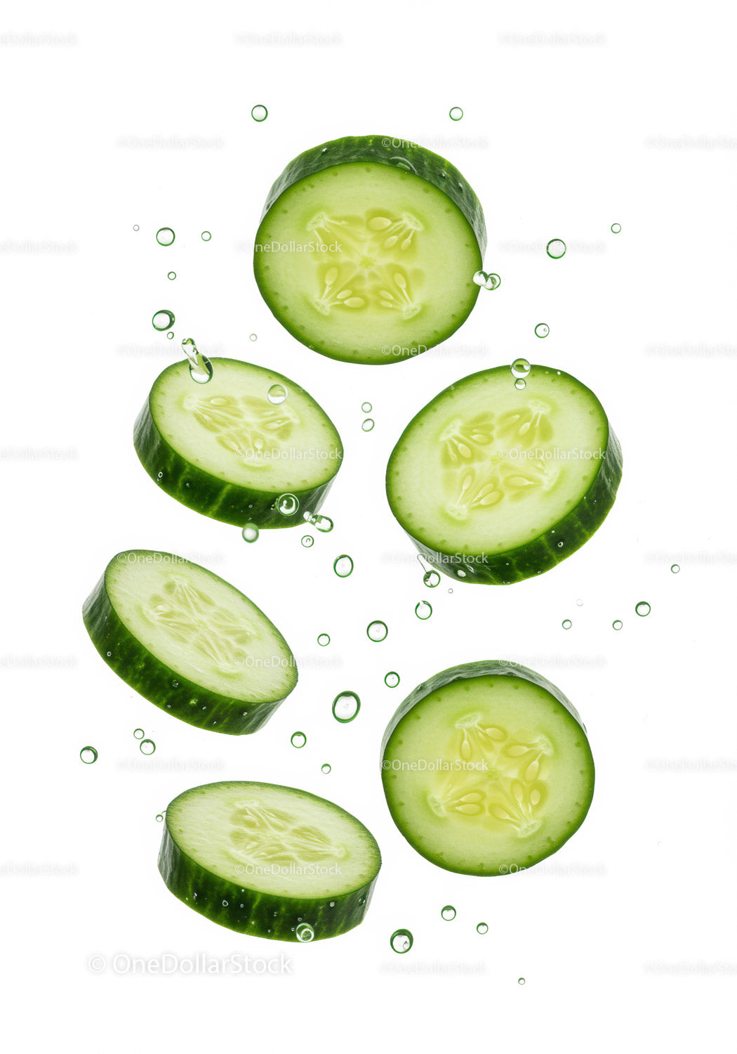 Fresh cucumber slices floating in clear water bubbles