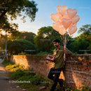 Man Holding Heart Balloons and Chocolates Outdoors