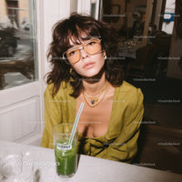 Chic Young Woman Wearing Sunglasses and Gold Jewelry in Cafe