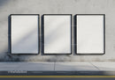 Three blank posters on weathered urban concrete wall