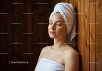 Relaxing Woman with Towel Wrap Resting Against Wooden Wall