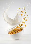 Splashing milk pouring into bowl of crunchy cereal
