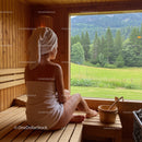 Serene Woman Relaxing in Sauna with Mountain Forest View
