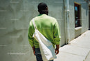 Urban Street Scene with Man in Green Sweater and White Tote Bag