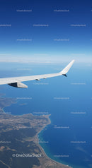 Aerial View of Airplane Wing Over Coastal Ocean Landscape