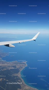 Aerial View of Airplane Wing Over Coastal Ocean Landscape