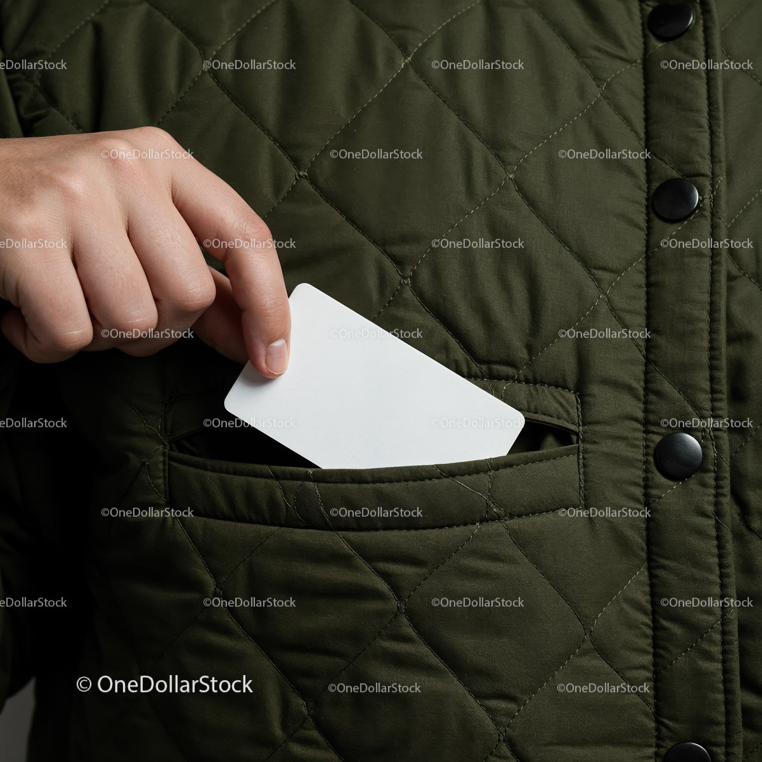 Hand Putting Blank Card into Green Quilted Jacket Pocket