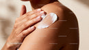 Close-up of woman applying moisturizer on shoulder
