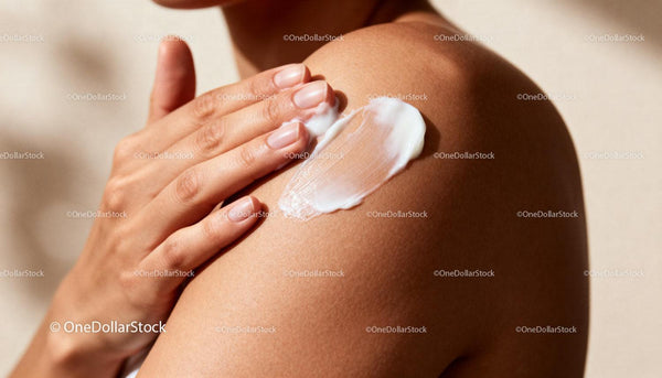 Close-up of woman applying moisturizer on shoulder