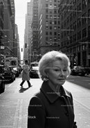 Elegant Elderly Woman Walking in Busy City Street