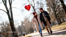 Couple Walking in Park Holding Heart Balloon