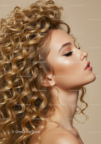 Profile of woman with voluminous curly hair and makeup
