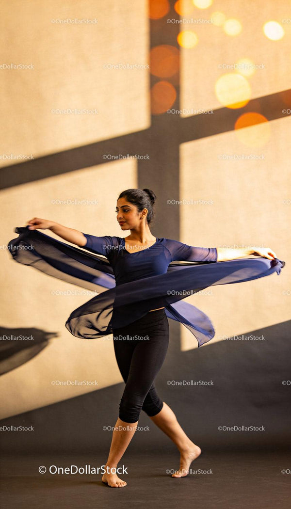 Graceful dancer spinning with flowing navy scarf