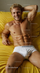Relaxed young man smiling on bright yellow bed