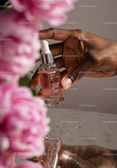 Close-up of hand with skincare serum dropper bottle with pink liquid