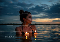 Woman in Black Bikini with Candles Floating in Lake at Sunset
