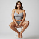 Confident Plus Size Woman Sitting Cross Legged on a Stool in Casual Wear