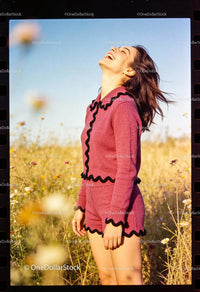 Young woman laughing joyfully in sunny wildflower field