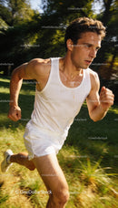 Focused male runner sprinting outdoors in summer sweat