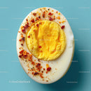 Hard Boiled Egg with Spicy Red Pepper Flakes on Light Blue Background