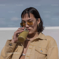 Young Woman Drinking Green Smoothie in Sunny Outdoor Setting