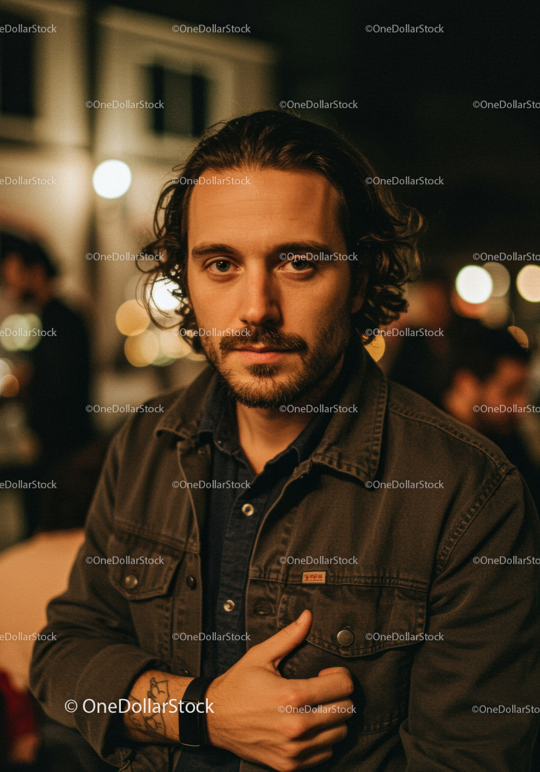 Pensive young man with beard in casual jacket at night