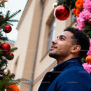 Young man admiring vibrant Christmas decorations outdoors