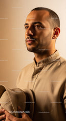 Elegant Male Portrait in Traditional Beige Outfit and Hat