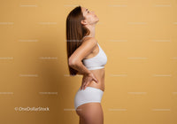 Elegant Woman in White Sportswear Posing Against Beige Background
