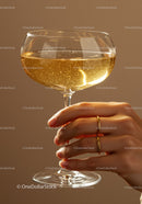 Hand holding sparkling champagne in elegant coupe glass